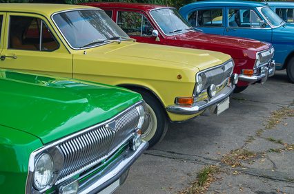 Vintage vehicles are in the parking lot on the city show.